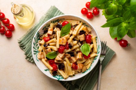 Photo for Top view of Italian, Sicilian dinner. Pasta with swordfish, tomato, and eggplant. Olive oil, vegetables. - Royalty Free Image