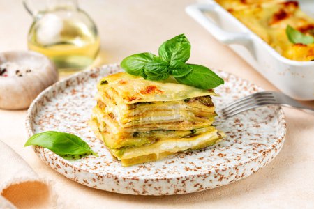 Photo for Lasagna with zucchini or courgette, ship cheese, bechamel sauce. Decorated with basil leaves. Vegetarian italian pasta dish. - Royalty Free Image