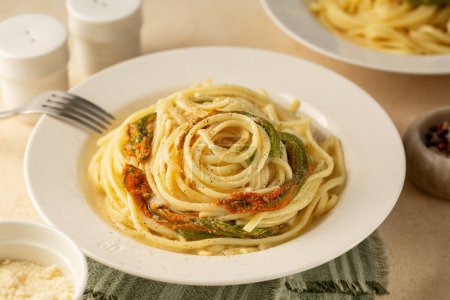 Téléchargez les photos : Pâtes italiennes, Spaghettis aux fleurs de courgettes, poivre noir et fromage. - en image libre de droit