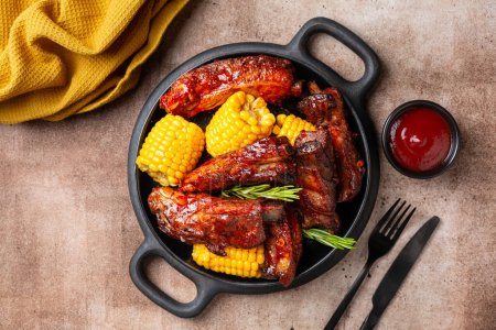 Photo for Plate with baked pork ribs with corn cobs, barbecue sauce, rosemary. Brown table background. Meat dinner. - Royalty Free Image