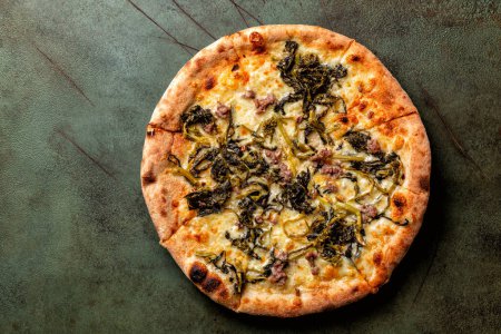 Foto de Vista superior de la pizza italiana con queso, salchichas y Rapini o brócoli rabe. Pizza napolitana salsiccia e friarielli. - Imagen libre de derechos