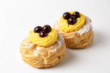 Photo for Zeppole di San Giuseppe, zeppola - baked puffs made from choux pastry, filled and decorated with custard cream and cherry.  Italian pastry traditional for Saint Joseph's Day. - Royalty Free Image
