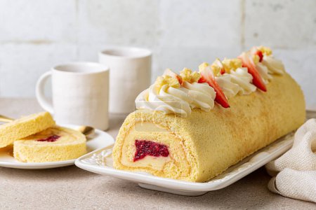 Photo for Rolled sponge cake filled with custard cream and berry jelly, decorated with whipped cream cheese and strawberries. Swiss or jelly roll cake, roulade or Swiss log. White background. - Royalty Free Image
