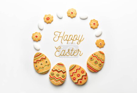 Téléchargez les photos : Biscuits en forme d'oeuf de Pâques, bonbons, bordure ronde avec texte de Pâques heureux. Carte de vœux créative. Fond blanc. - en image libre de droit