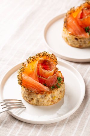 Photo for Smoked  salmon and vegetable flan or sformatino,  made with cauliflower, leek, egg, ricotta and parmesan cheese. Monoportion appetizers on a white plate, vertical image. - Royalty Free Image