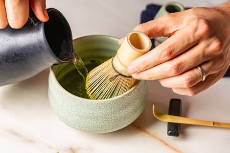 Photo for Man hands, Cooking green matcha tea during the Japanese ceremony. Traditiobal kit, Bamboo whisk and beverage, spoon shashaku, heated tea bowl known as a chawan, hot water - Royalty Free Image