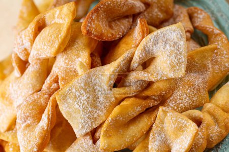 Photo for Close up of Angel wings or bugnes, bugie, or chvorost; faworki. Traditional sweet crisp pastry deep-fried and sprinkled with powdered sugar. - Royalty Free Image