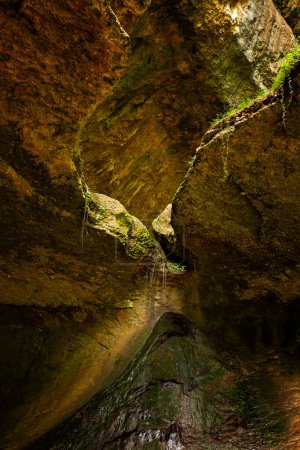 Italienischer Naturpark - doppio covolo Felsen und kleiner Wasserfall. Parco delle Cascate, Italien, Naturpark im Dorf Molina, Gardasee, Italien. Vertikales Bild.