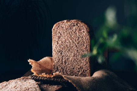 Photo for Sliced homemade wholemeal bread. Easy cooking at bread machine of healthy bread from alternative flours at home - Royalty Free Image