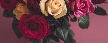 Foto de Ramo de rosas de colores. Hermoso ramo de rosas en variedad de colores sobre fondo rosa polvoriento. Tamaño del banner - Imagen libre de derechos