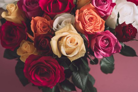 Foto de Ramo de rosas de colores. Hermoso ramo de rosas en variedad de colores sobre fondo rosa polvoriento. - Imagen libre de derechos