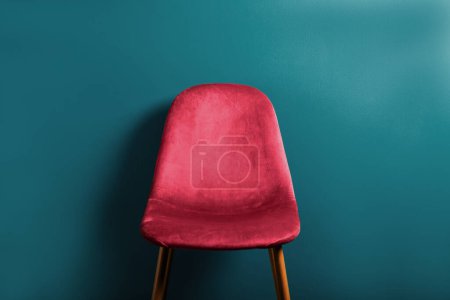 Téléchargez les photos : Chaise moderne en velours Viva Magenta, couleur de l'année 2023 sur pieds en bois, fond bleu - en image libre de droit
