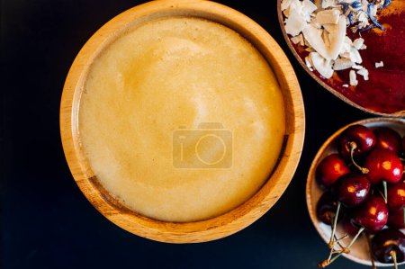 Photo for Smoothies from Banana and Pineapple and Banana and Cherries in the Coconut Shell Bowls - Royalty Free Image