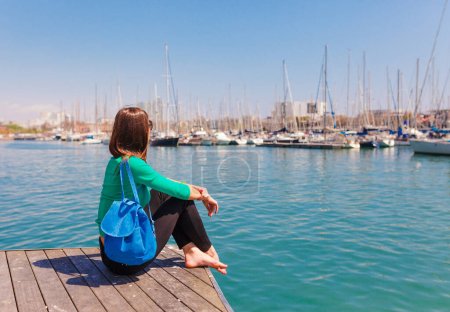 Foto de Mujer turista en el puerto de Barcelona, Cataluña, España. Paisaje marino escénico de marina y veleros yates. Paseo público y famoso destino turístico cerca de la calle La Ramblaa - Imagen libre de derechos