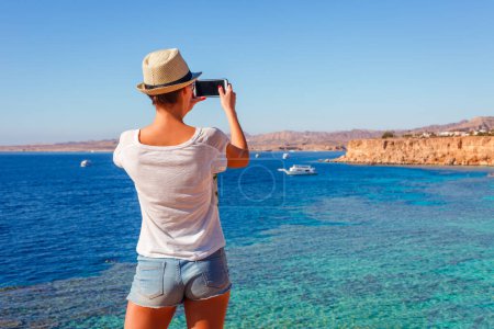 Foto de Mujer turística en la playa soleada resort en la costa del Mar Rojo en Sharm el Sheikh, Sinaí, Egipto, Asia en verano caliente. ? arrecife oral y agua cristalina. Famoso destino turístico buceo y snorkel - Imagen libre de derechos