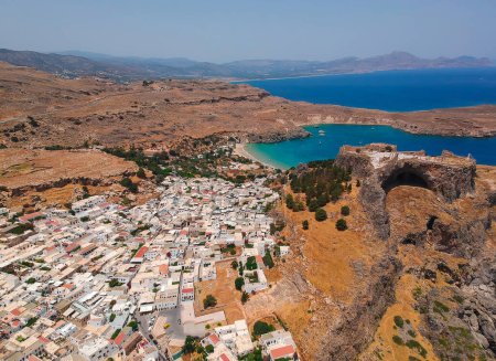 Photo for Aerial birds eye view drone photo of village Lindos, Rhodes island, Dodecanese, Greece. Sunset panorama with castle, Mediterranean sea coast. Famous tourist destination in South Europe. - Royalty Free Image