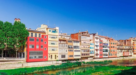 Photo for Colorful red, orange and yellow houses and bridge through river Onyar in Girona, Catalonia, Spain. Scenic ancient town. Famous tourist resort destination perfect place for holiday and vacation - Royalty Free Image