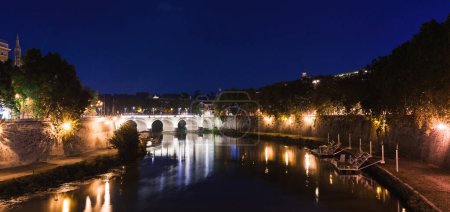 Photo for Cityscape romantic night view of Roma. Panorama with Saint Angelo castle and bridge. Famous tourist destination with Tiber. Travel illuminated landscape in Italy, Europe. - Royalty Free Image