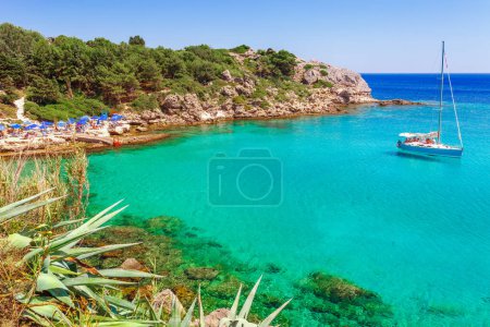 Foto de Vista al mar paisaje foto Bahía de Ladiko cerca de la bahía de Anthony Quinn en la isla de Rodas, Dodecaneso, Grecia. Panorama con bonita playa de arena y agua azul clara. Destino turístico famoso en el sur de Europa - Imagen libre de derechos