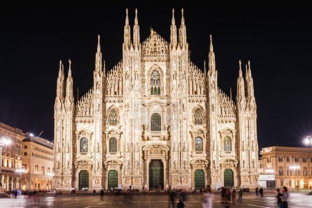 Foto de La turista de viaje alimenta a las palomas cerca del Duomo di Milano, la iglesia catedral de Milán en Italia. Chica disfrutando en la plaza en el centro de la ciudad, famoso destino para el viajero - Imagen libre de derechos