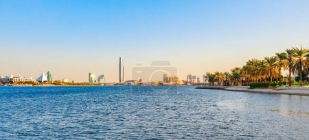Photo for Skyline view of Dubai Creek with palms and skyscrapers from the boat tourist trip. Sunset in sunny summer day. Dubai is famous tourist destination in UAE. Mix modern and old lifestyle in Dubai - Royalty Free Image