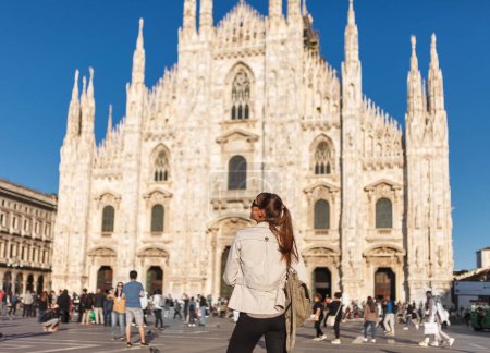 Foto de La turista de viaje cerca de Duomo di Milano - la iglesia catedral de Milán en Italia. Blogger girl disfrutando en la plaza en el centro de la ciudad, famoso destino para los viajeros - Imagen libre de derechos