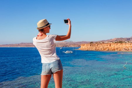 Foto de Mujer turística en la playa soleada resort en la costa del Mar Rojo en Sharm el Sheikh, Sinaí, Egipto, Asia en verano caliente. ? arrecife oral y agua cristalina. Famoso destino turístico buceo y snorkel - Imagen libre de derechos