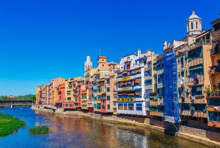 Téléchargez les photos : Maisons colorées rouges, orange et jaunes et pont à travers la rivière Onyar à Gérone, Catalogne, Espagne. Ancienne ville pittoresque. Destination touristique célèbre endroit idéal pour des vacances et des vacances - en image libre de droit