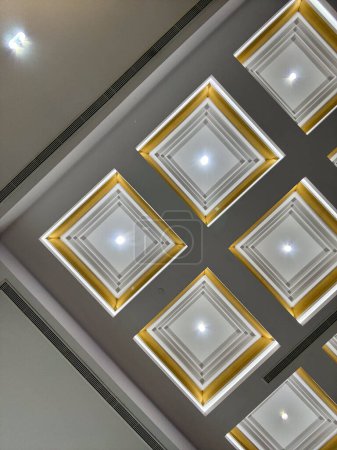 Foto de La imagen muestra un techo con múltiples luces incrustadas en él, iluminando el espacio con un brillo suave. Las luces se separan uniformemente a través del techo, creando un ambiente bien iluminado. - Imagen libre de derechos