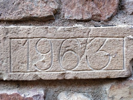 Vue rapprochée détaillée d'un mur de briques altérées, affichant bien en vue un numéro peint. Les briques montrent des signes de vieillissement et d'usure, ajoutant du caractère à la scène urbaine.