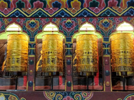 Traditionelle tibetische Gebetsmühlen mit bunten Mustern im Hintergrund Nahaufnahme.
