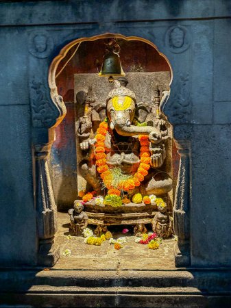 Téléchargez les photos : Une photo de la statue du dieu hindou Ganesha du temple kala Ram à Nashik. Les statues sont dans un temple et sont entourées d'une pièce sombre - en image libre de droit