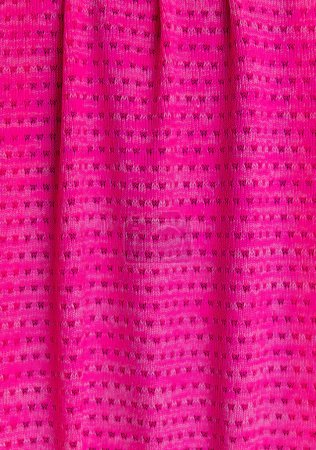 Makro aus fein gemustertem rosa Stoff. Vorhang mit vertikalen Falten, mit kleinen Musteröffnungen. Hintergrund.