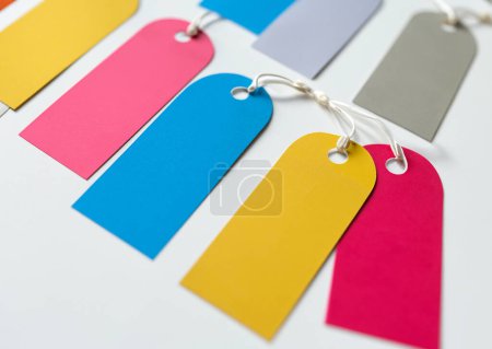 Photo for Hanging paper blank labels. Background with colorful tags with holes and string in white background. - Royalty Free Image