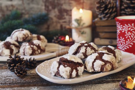 Chocolate Crinkle Cookies  in powdered sugar and Christmas decoration, rustic style, toned image