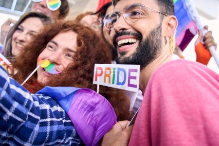 Close up diverse group of happy young people taking funny selfie for social media celebrating gay pride festival day. Lgbt community concept cheerful friends outdoors. Generation z enjoy party.