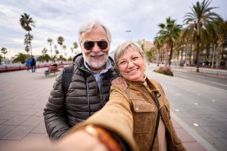 Photo for Happy Caucasian senior tourist couple take selfie together. Husband and wife love smiling looking at camera enjoying pensioner journeys in European city street. Older people retirees sightseeing - Royalty Free Image