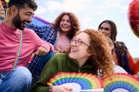 Grupo de jóvenes diversos que sonríen en el día del festival del orgullo gay celebrando fans del arco iris. Amigos de la comunidad LGBT alegres y divertidos al aire libre. Lesbianas, homosexuales, transgénero y no binarias