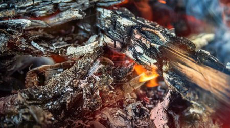 Téléchargez les photos : Fond flou de bois de chauffage fumant et brûlant dans le gril, dans des tons rouge-orange. focus flou - en image libre de droit