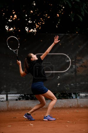 Foto de Gran vista de una jugadora de tenis deportiva activa con raqueta de tenis en la mano haciendo pitch - Imagen libre de derechos