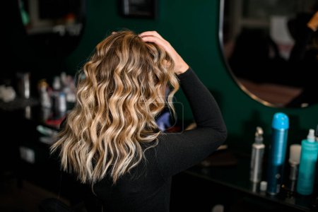 Téléchargez les photos : View of woman with perfect hairstyle of curl hair in hair salon. Hairdo for holiday or for everyday. Beauty salon and hairstyle concept - en image libre de droit