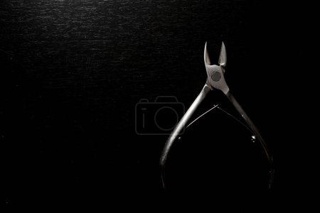 Téléchargez les photos : Un nouvel outil en métal acier brillant cuticule pinces à manucure sur fond noir isolé, ensemble pédicure - en image libre de droit
