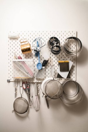 Photo for Kitchen wall organizer that holds sieves, silicone spatulas, spoons and other various confectioners accessories, isolated - Royalty Free Image