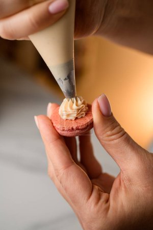 Série visuelle capturant les étapes complexes de l'artisanat des macarons beiges, soulignant l'ajout de remplissage crémeux