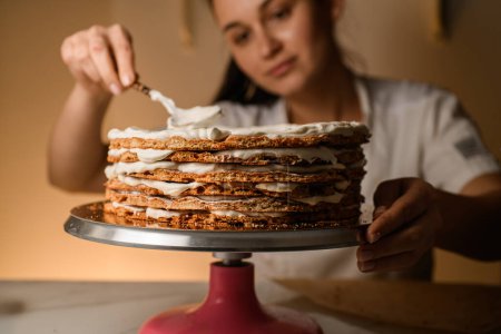 Pastry chef diligently whips cream, striving for cake perfection in every dollop.