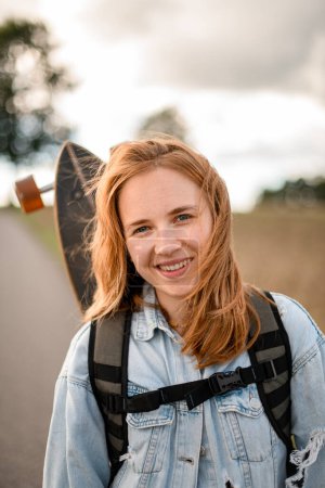 Exuding happiness, she stands with a longboard, her smiling charm adding a delightful touch.