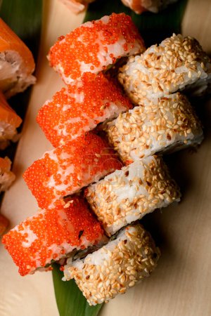 delightful assortment of sushi rolls, topped with tobiko caviar and sesame, beautifully presented from an overhead perspective.