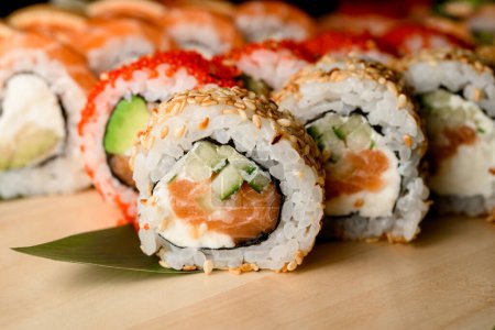 intimate view capturing the intricate details of sushi rolls featuring tobiko caviar, sesame, and a delectable sauce.