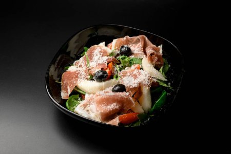 Genießen Sie einen erfrischenden Salat mit einer Mischung aus Gemüse, Oliven und Thunfisch, verstärkt durch die köstliche Zugabe von Parmesan-Streusel.