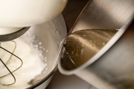 Färbung und Zubereitung von geschlagener weißer Sahne zur Dekoration von gebackenen Mandelmehl-Macarons. Professioneller kulinarischer Spezialist